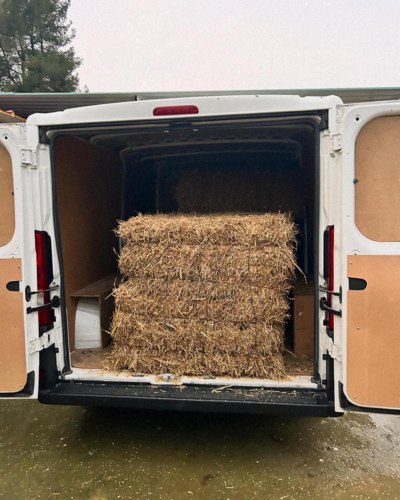 Furgoneta cargada con pacas de heno para portes en Madrid.